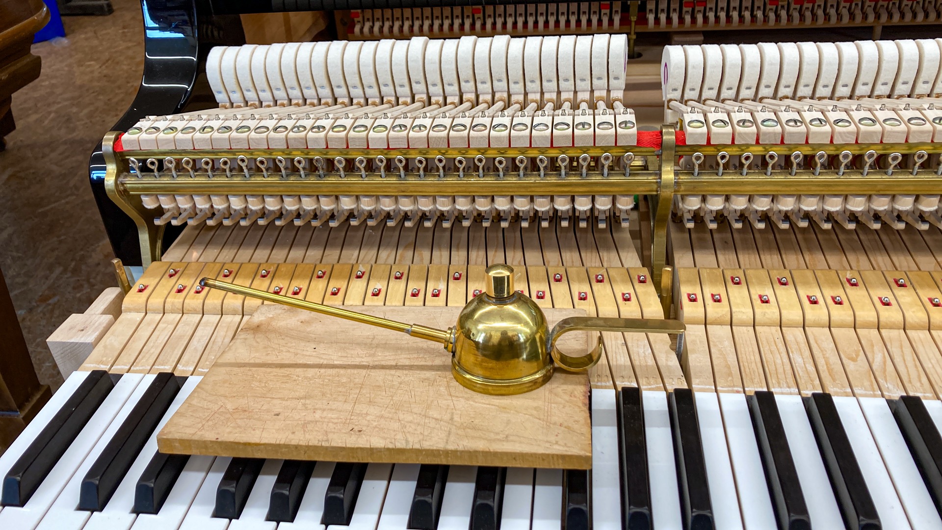 Piano action – detail shot with oiler during maintenance service